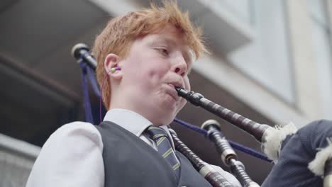 Young-street-performer-with-ginger-hair-playing-his-bag-pipes