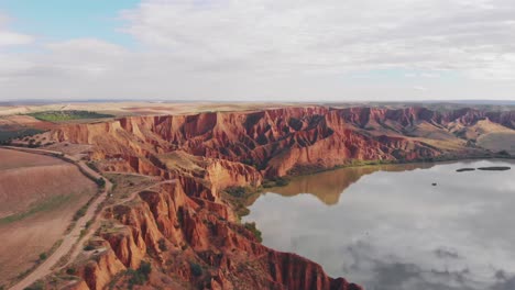 drone volador sobre gargantas y acantilados estrechos y profundos naturales junto a un lago de agua en barrancas de bujuron