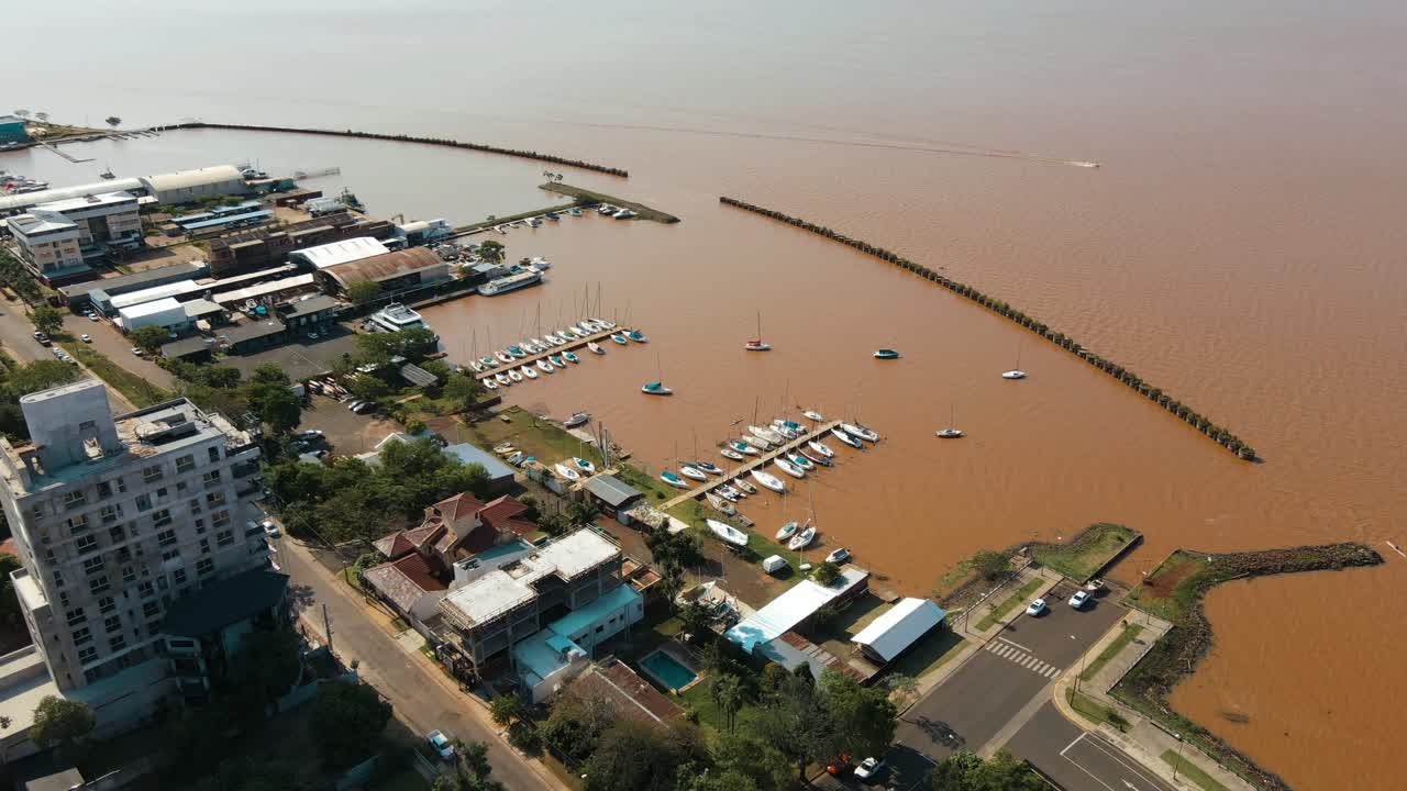 Aerial view showcasing a marina in the city of Posadas, Argentina, with the brown waters of the Paran&aacute; River in the backdrop