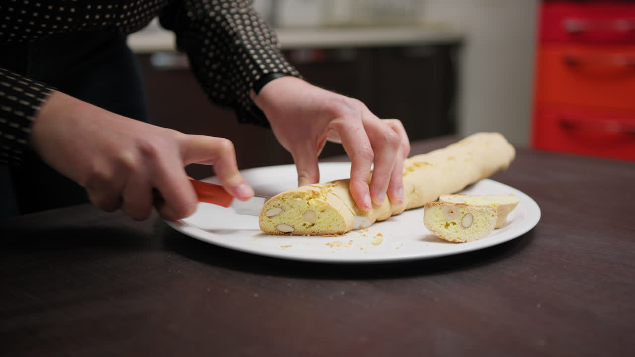 In a Home Kitchen A Hand Cuts Cantucci Biscuits Before Second Baking In Oven