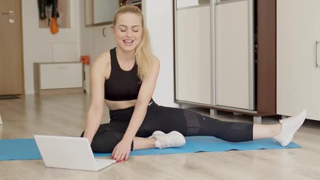 Attractive-young-woman-doing-yoga-stretching-online-at-home--Self-isolation