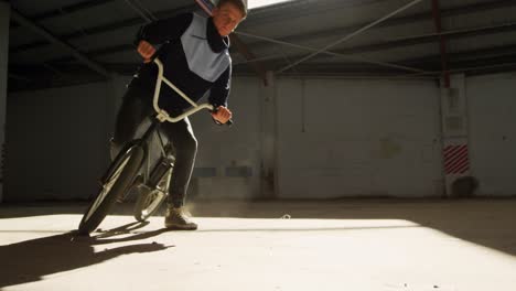 bmx rider in an empty warehouse