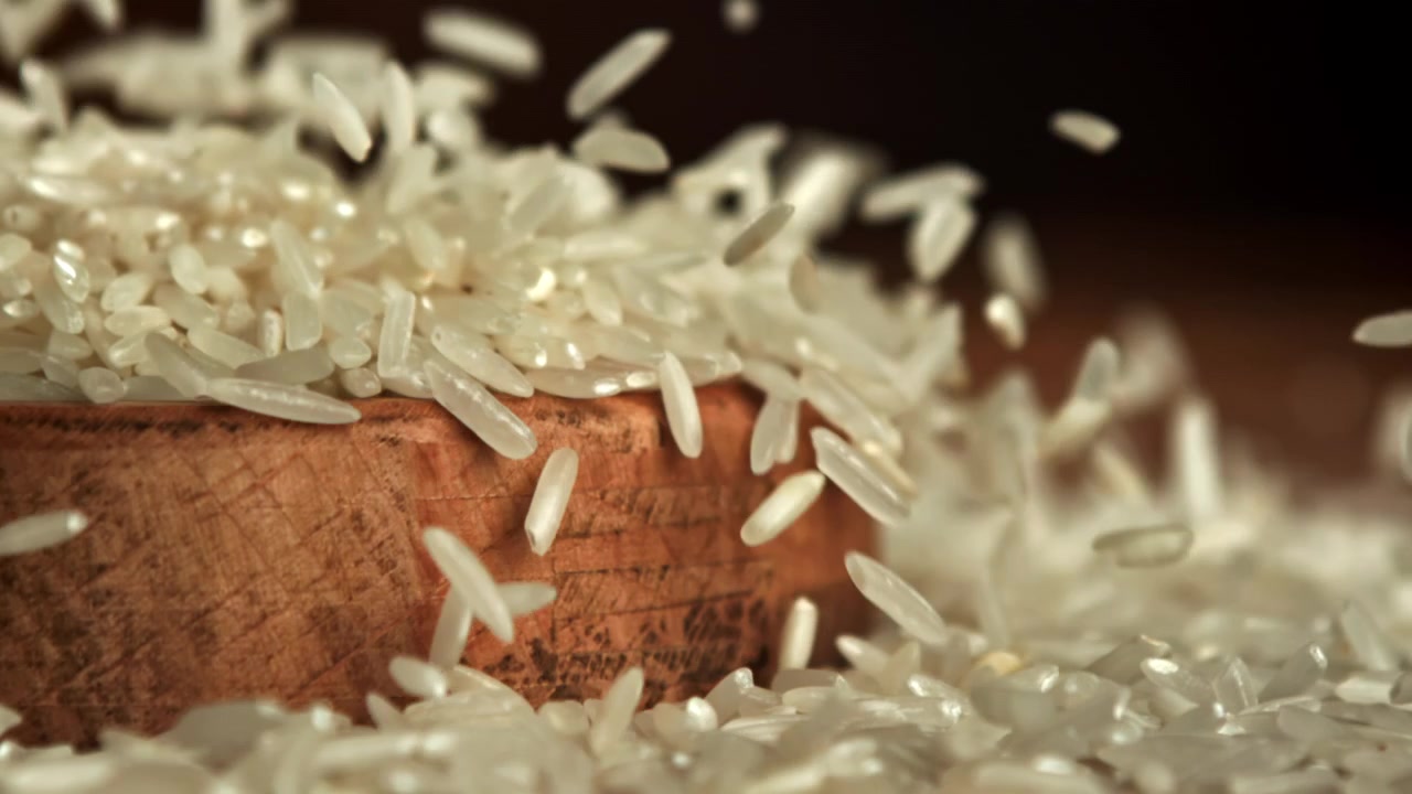 Hvide risgryn falder og hopper i slowmotion.