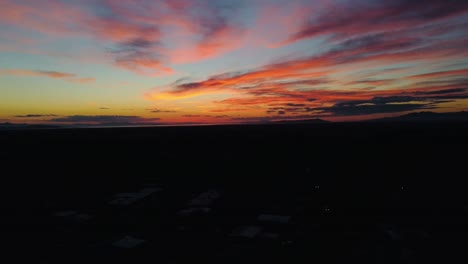 dron volando sobre el vecindario hacia la hermosa puesta de sol de la hora dorada con nubes de colores brillantes, que parece como si no se moviera a ninguna parte