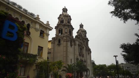 una iglesia o catedral alta llamada "virgen milagrosa" ubicada en lima, peru en el distrito de miraflores muy cerca de un parque publico llamado "parque kennedy"