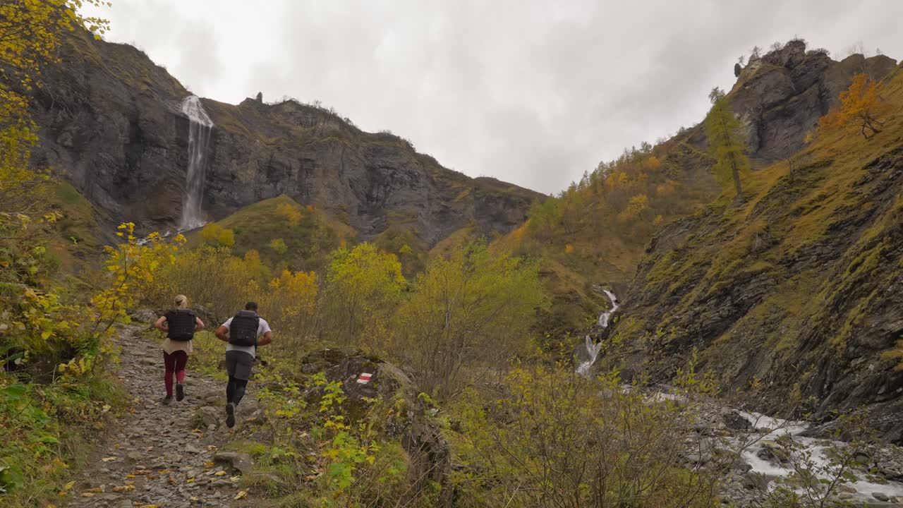 Couple walking towards Batoni Waterfalls in untouched natural canyon