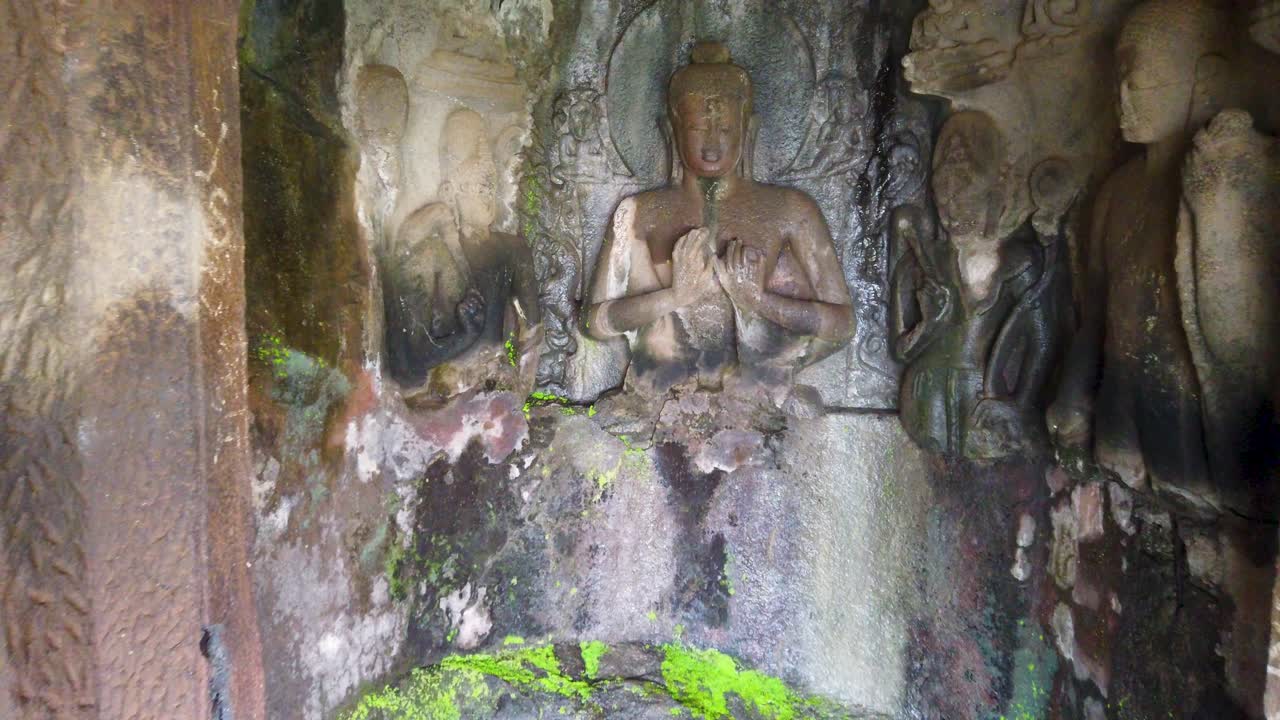 estatua de buda tallada en la pared en las cuevas pandav leni en nashik, india - enfoque