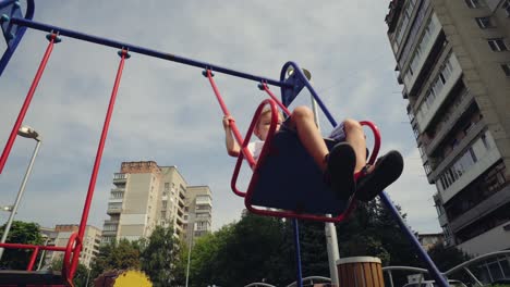 un niño se balancea en un columpio en la ciudad 04