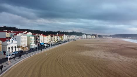 Luftaufnahme-Entlang-Der-Strandpromenade-Von-Nazare-An-Bewölktem,-Bewölktem-Tag