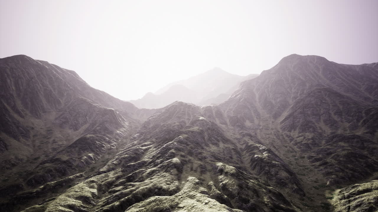 Majestic mountains rise under a soft glow in a serene landscape setting