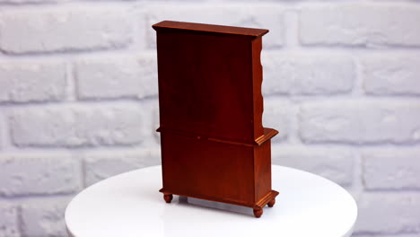 beautiful old-fashioned cupboard of brown wood. lovely piece of toy furniture at the rotating table. close up.