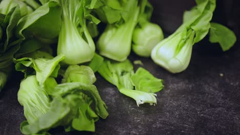 Panorámica-Sobre-Una-Selección-De-Baby-Bok-Choi-Fresco-En-La-Cocina-Asiática