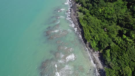 Spritzende-Wellen-Am-Ozeanriff-In-Cape-Tribulation-Mit-Daintree-regenwald,-Queensland,-Australien