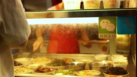 vendor preparing food at a busy stall