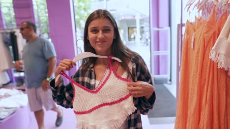 mujer intentando una camiseta de ganchillo en una tienda de ropa