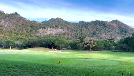 beautiful golf course landscape with mountains in background