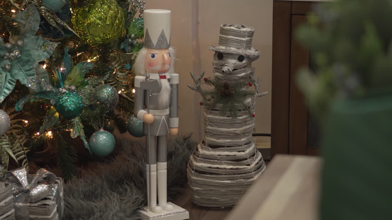 Close-up of decorative nutcracker and snowman figures decorating Christmas tree in living room at home.