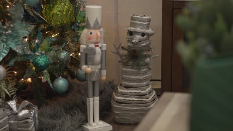close-up of decorative nutcracker and snowman figures decorating christmas tree in living room at home.