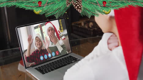 Animación-De-Decoraciones-Navideñas-Sobre-Una-Chica-Caucásica-Con-Sombrero-De-Santa-En-Una-Videollamada-Portátil-Con-Familia