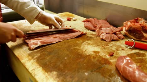 butcher slicing meat with knife