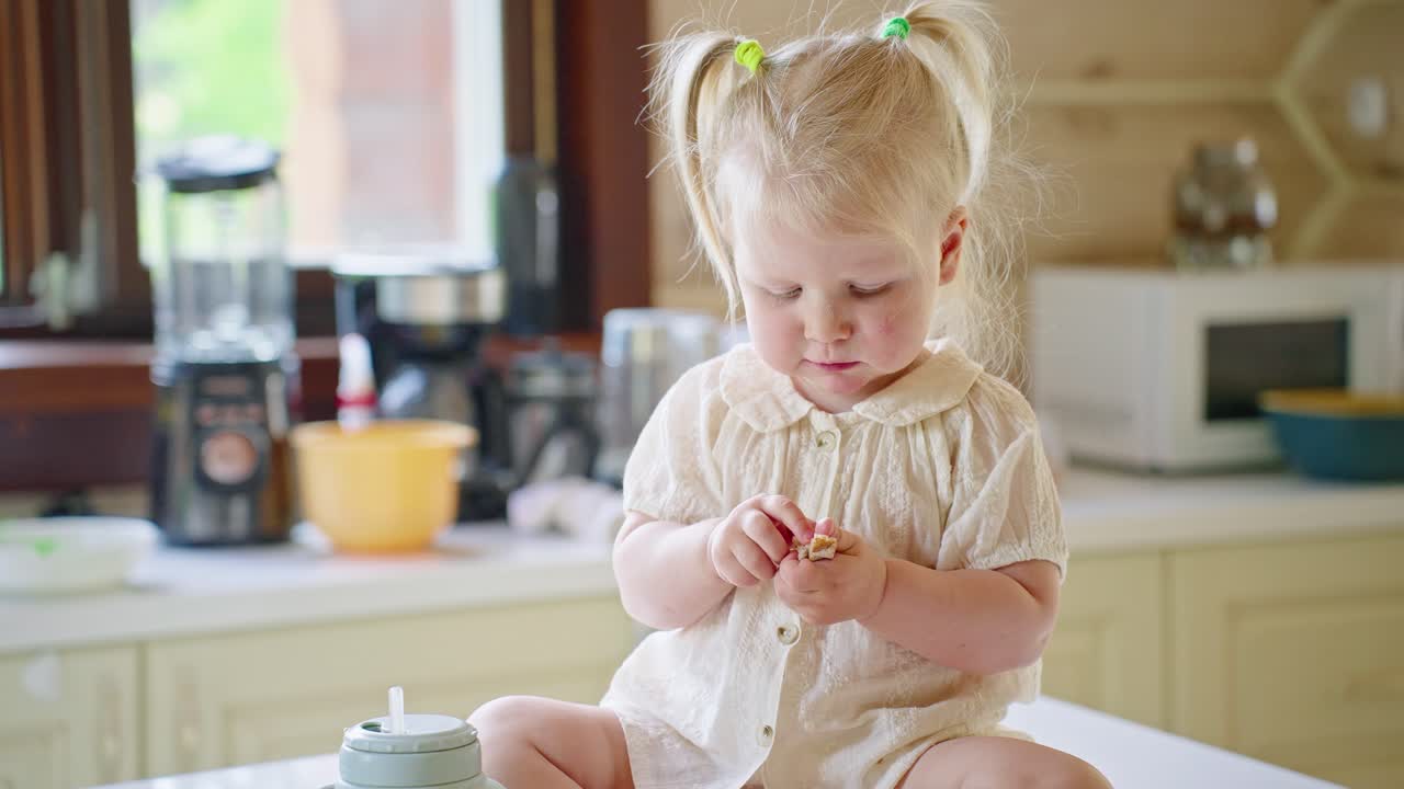 Toddler eating finger food in the kitchen