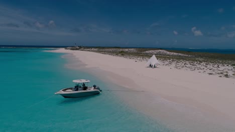 drone shot private camp beach tent glamping, speedboat moored, cayo de agua island