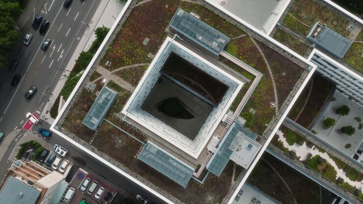Plano ascendente com drone revelando um edifício com átrio e teto verde em um complexo moderno
