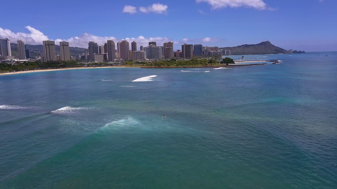 Veduta aerea di un paddle boarder solitario che naviga lungo la costa sud di Oahu.