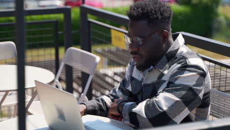 man working on laptop in outdoor cafe