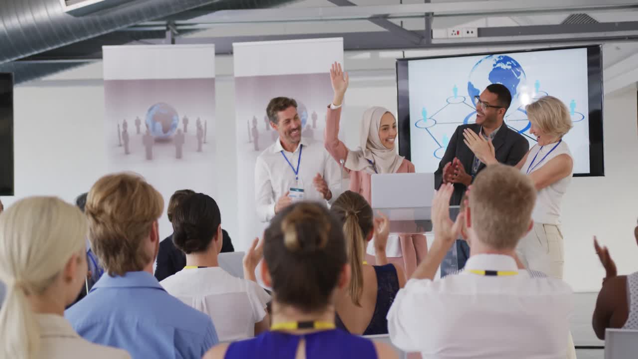 Relatrice, pubblico e colleghi che applaudono a una conferenza aziendale