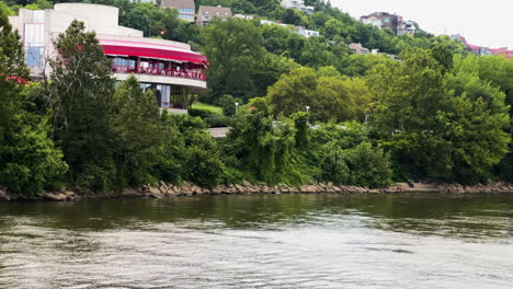 sailing over calm water of the ohio river near cincinnati riverfront city in ohio, usa