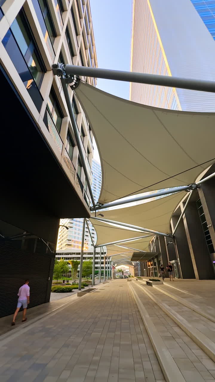 Tents set between the buildings as the protection from the hot sun in summer. A walk by the streets of Bratislava, Slovakia. Vertical video.