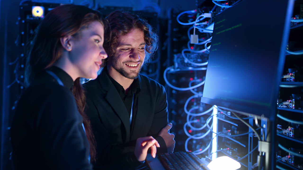 A man and a woman cheering in a server room