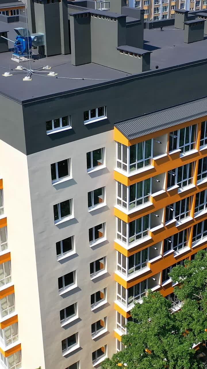 Modern residential complex in the city. Motion camera view of the newly built apartment buildings in sunny daytime. Exterior of new urban infrastructure concept Vertical video