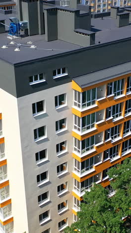 modern residential complex in the city. motion camera view of the newly built apartment buildings in sunny daytime. exterior of new urban infrastructure concept vertical video