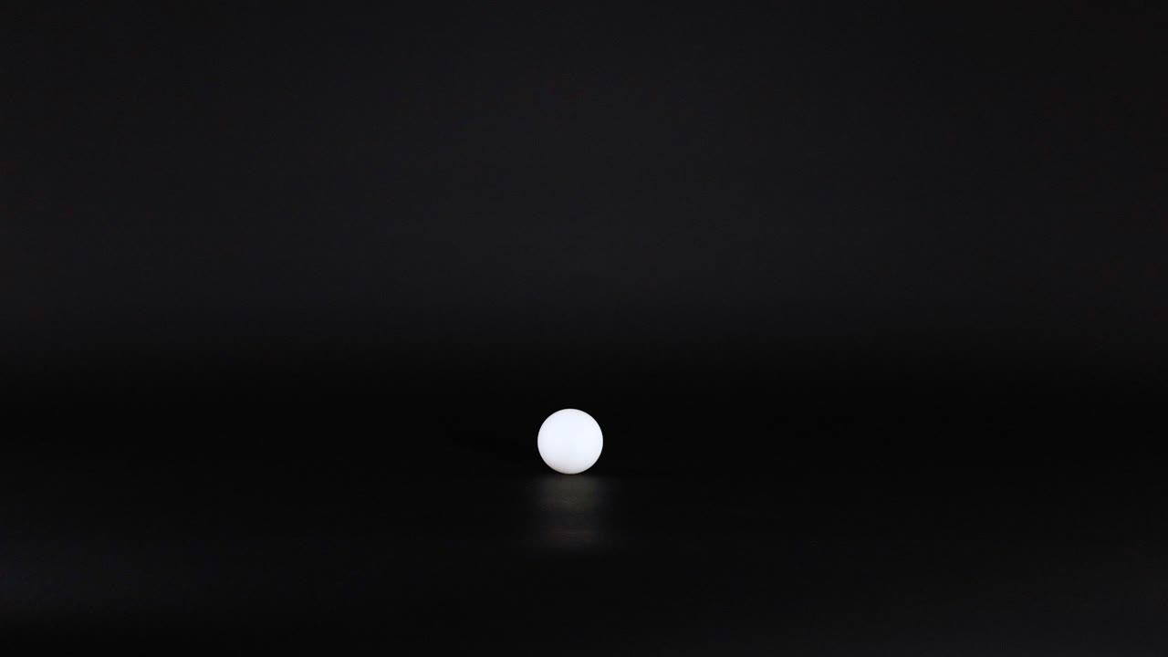 A ping pong ball rolls across a surface
