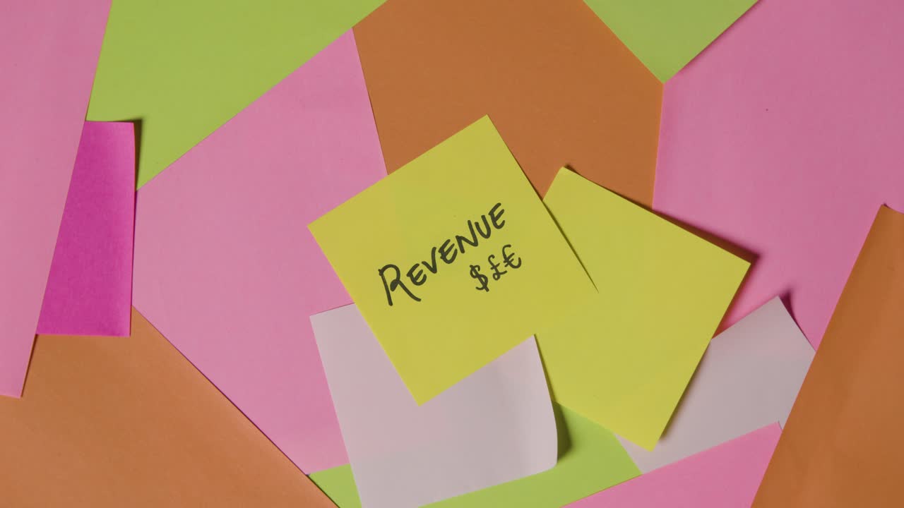 상단 메모에 기록된 수익이 있는 회전 스티커 메모의 비즈니스 개념