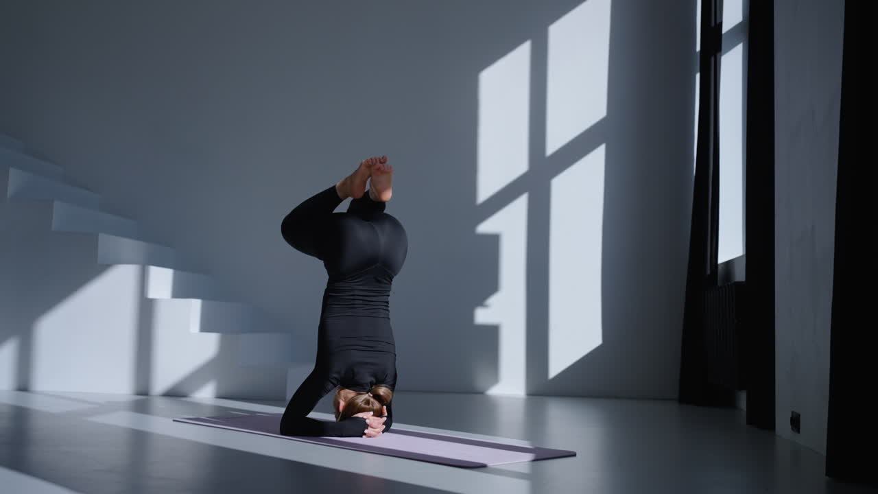 Kvinde praktiserer yoga i et studie