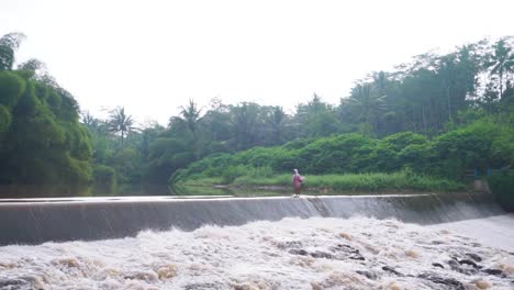 Una-Anciana-Cruza-Una-Presa-En-Magelang,-Indonesia