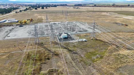 drone footage captures a high-voltage power substation amidst an autumn landscape in lake tekapo, showcasing infrastructure and transmission lines