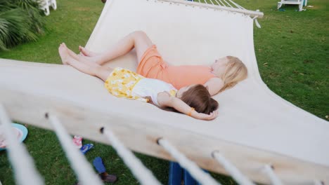 two girls in bright summer clothes are lying on the deckchair, having fun, enjoying the rest. view from above