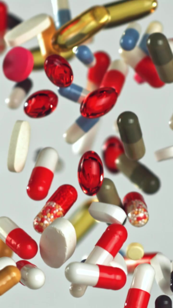 Colorful Pills and Capsules Falling in Slow Motion