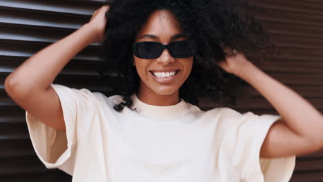 smiling woman with curly hair and sunglasses