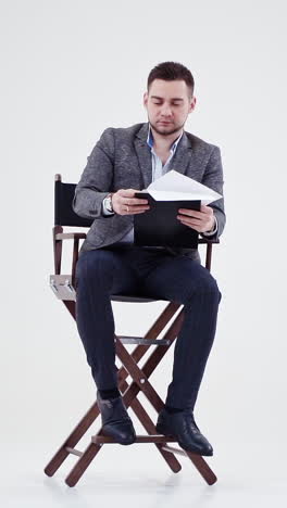 businessman reading documents in a director's chair
