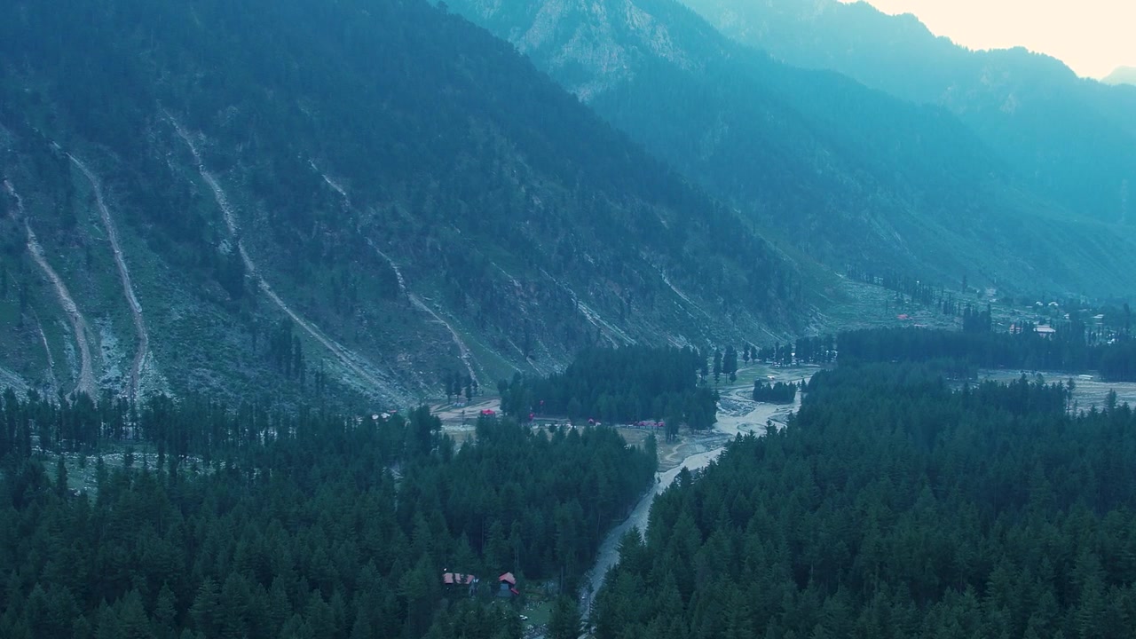 Gęsty las iglasty otacza rzekę i równinę zalewową u podnóża zboczy górskich, Dolina Kumrat, Chajber Pasztunchwa, Pakistan.