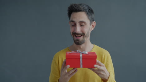 man excitedly holding a gift box