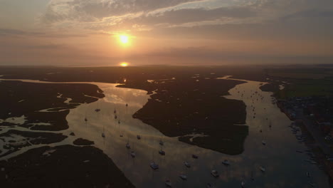 Drone-Disparó-Sobre-La-Ciudad-Costera-En-Un-Hermoso-Amanecer-Impresionante-Con-Marea-Alta-Con-Veleros-Y-Marismas-Y-Arroyos-En-Pozos-Al-Lado-Del-Mar-Norte-De-Norfolk,-Costa-Este-Del-Reino-Unido