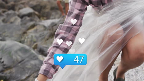 woman picking up litter on rocky shoreline, showing marketing ad with heart icons and like counter