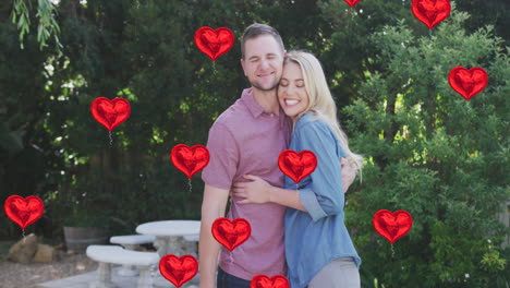 animation of heart balloons over happy caucasian couple in garden
