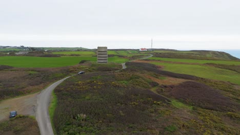 Guernsey-Pleinmont-flight-over-German-watchtower-heading-inland-towards-BBC-communications-tower-over-heathland-and-farmland-on-cloudy-day